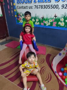 Group of happy preschool children standing in front of a summer camp welcome board at Rose Play School