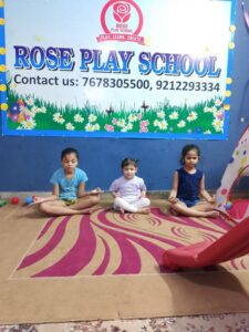 Group of happy preschool children standing in front of a summer camp welcome board at Rose Play School